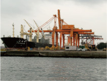 クレーンで積み下ろしをする船舶の画像